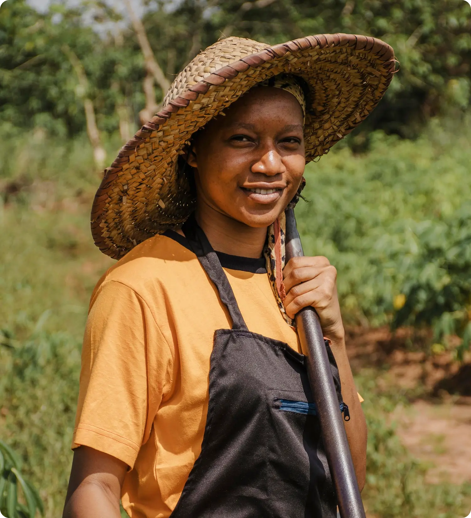 a woman smiling with a hoe in her hand